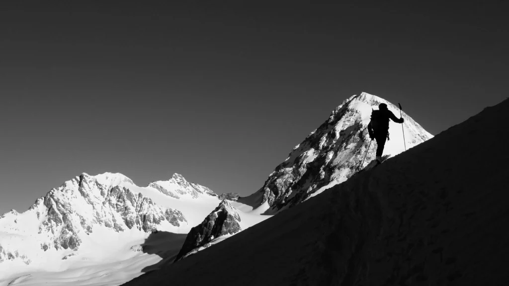 Schwarz-Weiß-Bild mit dem Monte Cevedale und einem Skitourengeher. Foto von Giacomo Berardi-Unsplash