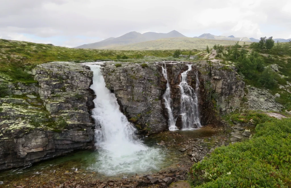 Nationalpark Rondane mit Wasserfälle, Berge und Wolken im Hintergrund. Foto von Kato Bergli-Unsplash