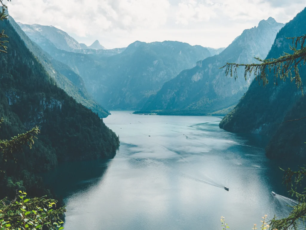 Berchtesgadener Alpen mit Königssee und Wolken im Hintergrund. Foto von Simon Maisch-Unsplash