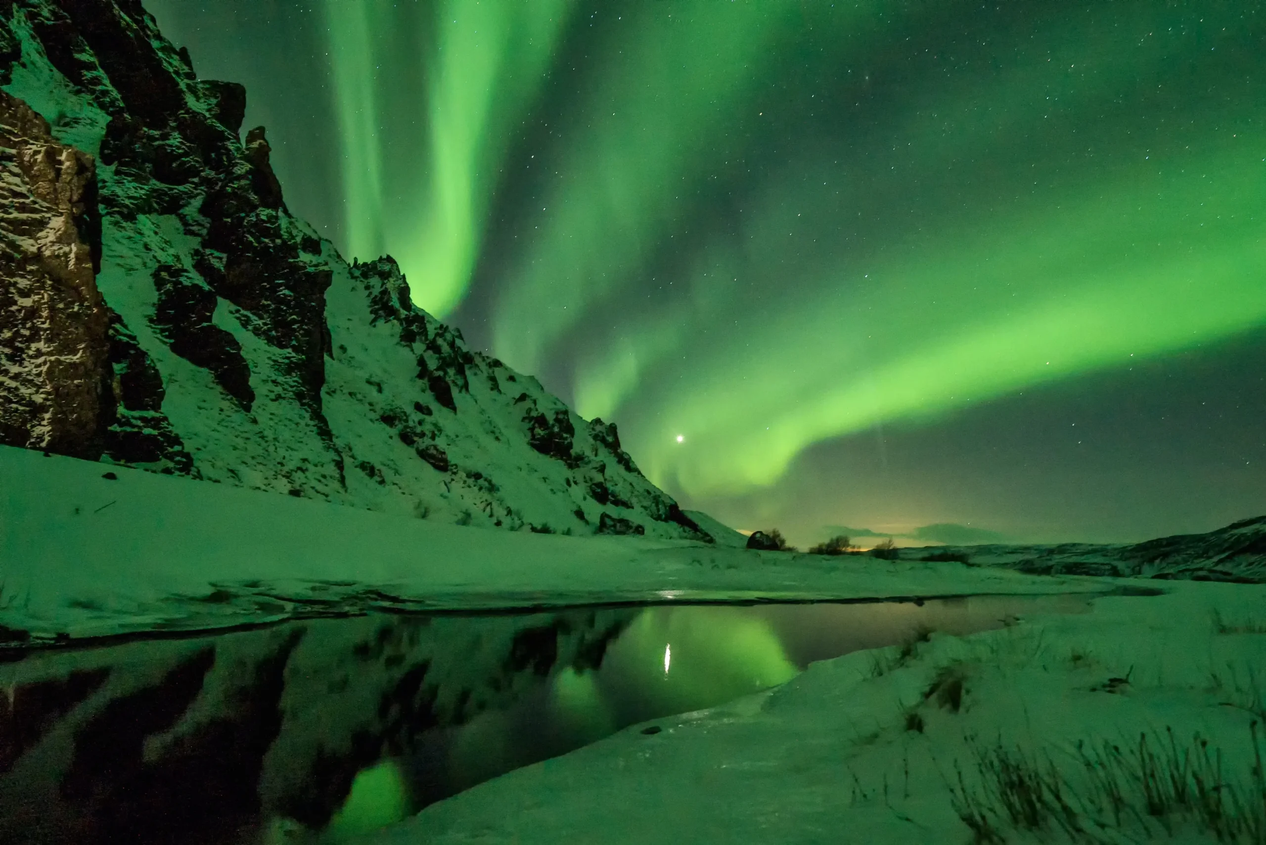 Grünes Nordlicht mit Berg und Wasser. Foto von Jonatan Pie-Unsplash